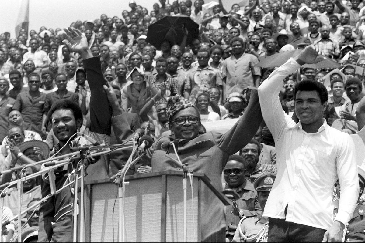 Ảnh tư liệu về Chủ tịch Zaire Mobutu Sese Seko (giữa) khi ông giơ tay nhà vô địch hạng nặng George Foreman (trái) và Muhammad Ali (phải) Ảnh tư liệu về Chủ tịch Zaire Mobutu Sese Seko (giữa) khi ông giơ tay nhà vô địch hạng nặng George Foreman (trái) và Muhammad Ali (phải)