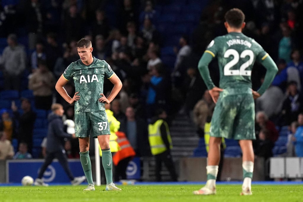 Micky van de Ven của Tottenham, trái, và Brennan Johnson trông chán nản sau thất bại trước Brighton. Ảnh: AP