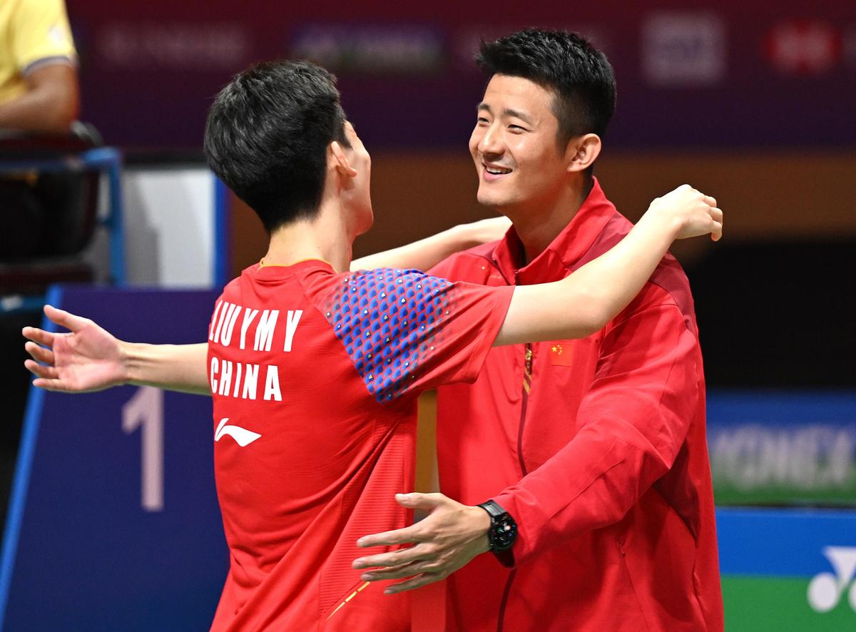 Huấn luyện viên tuyển Trung Quốc Chen Long (phải) chúc mừng Liu Yang Ming Yu (trái) sau khi đánh bại Mohd. Zaki Ubaidillah của Indonesia trong trận chung kết đơn nam.